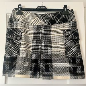 Teenflo skirt with 2 front/side patch pockets and kick pleat. Classic plaid.